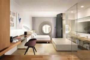 um quarto com uma cama, uma secretária e uma cadeira em Palazzo Montemartini Rome, A Radisson Collection Hotel em Roma