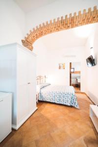 sypialnia z białymi ścianami i łóżkiem w pokoju w obiekcie Agriturismo Irghitula w mieście Posada +84 zdjęcia