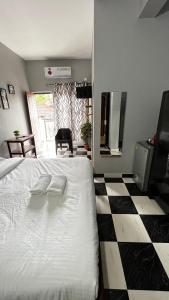 a bedroom with a white bed and a checkered floor at Casa Almeida Hotel in Candolim