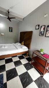 a bedroom with a bed and a checkered floor at Casa Almeida Hotel in Candolim