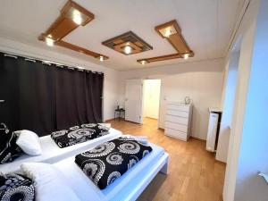 2 camas en una habitación con almohadas blancas y negras en Sehr große Ferienwohnung, Apartment in Kaiserslautern WeHome Komfort, en Kaiserslautern