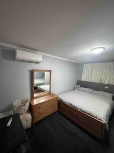 um quarto com uma cama, um espelho e uma cadeira em Resort style home pool spa sauna em Phillip