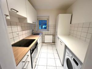 cocina blanca con fregadero y lavavajillas en Sehr große Ferienwohnung, Apartment in Kaiserslautern WeHome Komfort, en Kaiserslautern