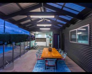 a patio with a wooden table and chairs at Resort style home pool spa sauna in Phillip