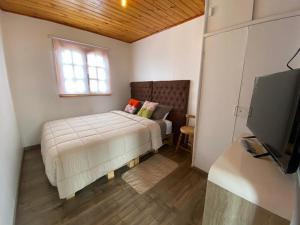 um quarto com uma cama, uma janela e uma televisão em Hostal La Casona em Papudo