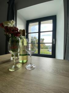 - une table avec 2 verres à vin et une bouteille de vin dans l'établissement Brennerei Federow, à Federow