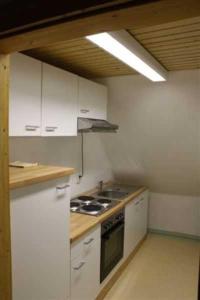 a kitchen with white cabinets and a stove top oven at Landhaus Damerow 1 in Federow