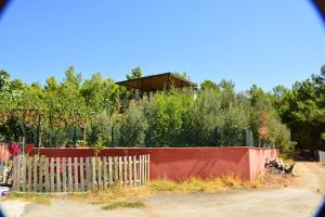une clôture avec une maison en arrière-plan dans l'établissement ormanın içinde geniş havuzlu triplex villa, à Manavgat