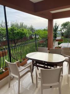 una mesa blanca y sillas en un balcón con vistas en ormanın içinde geniş havuzlu triplex villa en Manavgat