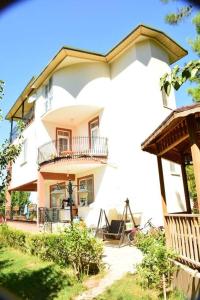 - un grand bâtiment blanc avec un balcon dans l'établissement ormanın içinde geniş havuzlu triplex villa, à Manavgat