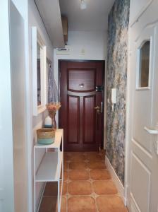 a hallway with a brown door and a white cabinet at APARTAMENT NIEBO in Kołobrzeg