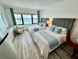 ein Hotelzimmer mit 2 Betten und einem Stuhl in der Unterkunft Directly on the Beach with Pool & Ocean View in Miami Beach