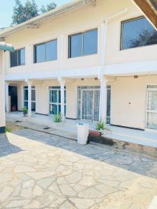 a large white house with a stone driveway at Royal Olympia Lodge Lusaka in Lusaka