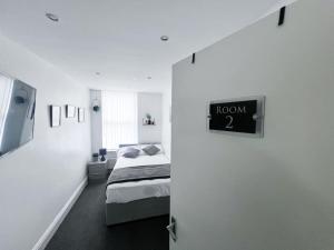 una camera con un letto e un cartello che legge la stanza di Cosy Flat by Anfield: 5 Minutes from the Stadium! a Liverpool