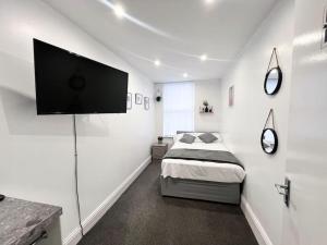 a bedroom with a bed and a flat screen tv at Cosy Flat by Anfield: 5 Minutes from the Stadium! in Liverpool