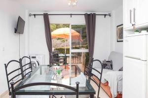 a dining room with a glass table and an umbrella at La Manga Club 2 Bed Apartment Great location in Murcia