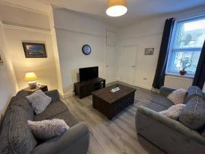 a living room with two couches and a tv at Blossom Holiday Lets - 3 Bed Bensham Apartment in Gateshead