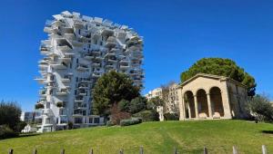 um edifício no topo de uma colina ao lado de um edifício em Face à l'Arbre Blanc, Neuf Clim Parking em Montpellier