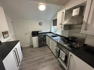 a kitchen with a stove and a dishwasher at Blossom Holiday Lets - 3 Bed Bensham Apartment in Gateshead