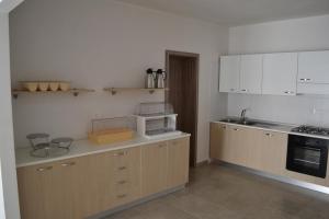 a kitchen with white cabinets and a counter with a microwave at B&B Coppularossa in Carovigno