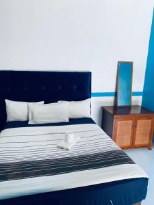 a blue and white bed with a white bowl on it at Royal Olympia Lodge Lusaka in Lusaka