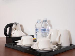 a tray with cups and bottles of water on a table at Le Kree Downtown Hotel in Phnom Penh