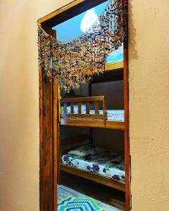ein Etagenbett aus Holz mit einem Kronleuchter in einem Zimmer in der Unterkunft Casa da Praia.Atins in Atins