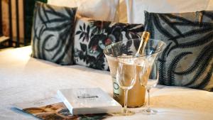 a table with two glasses and a book on a bed at Hotel Indigo Brussels - City, an IHG Hotel in Brussels