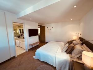 um quarto com uma cama grande e uma televisão em Exclusive Comfy Apartment in Central Crans-Montana em Lens