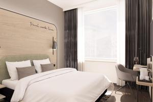 June Six Hotel Hannover City في هانوفر: غرفة نوم بسرير ومكتب ونافذة