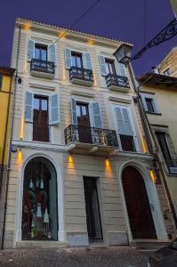 een wit gebouw met ramen en balkons aan een straat bij L'Olmo vestito in Teramo