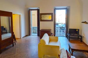 a living room with a yellow couch and a tv at L'Olmo vestito in Teramo