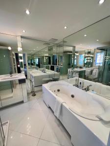 un ampio bagno con grande vasca e specchi di Exclusive Comfy Apartment in Central Crans-Montana a Lens