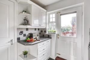 a kitchen with white cabinets and a bowl of fruit on the counter at The Escape in Nottingham