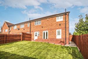 a brick house with a fence and a yard at The Escape in Nottingham
