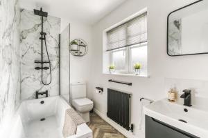 a white bathroom with a toilet and a sink at The Escape in Nottingham