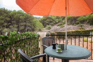 a table with an umbrella and two mugs on it at La Manga Club 2 Bed Apartment Great location in Murcia