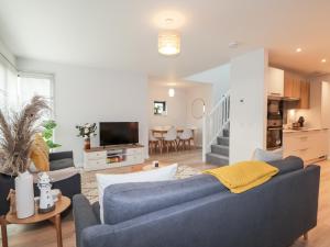 a living room with two blue couches and a television at Bonnieview in Lossiemouth