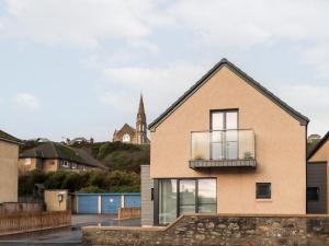 a house with a balcony and a church in the background at Bonnieview in Lossiemouth