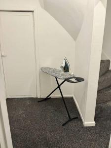 a hat sitting on a stool next to a staircase at Spacious Accommodation for Contractors and Families 4 Bedrooms, Sleeps 8, Smart TV, Netflix, Parking, Only 20 Minutes to Birmingham, M6 J9 in Darlaston