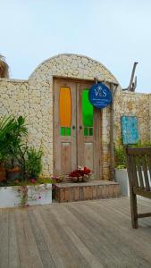 un edificio con una porta in legno e una panca di VnS Beachfront Guesthouse a Nusa Penida