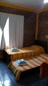 Duas camas num quarto com uma janela em Posada del Flamenco em Miramar (Córdoba)