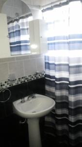 a bathroom with a sink and a shower curtain at Posada del Flamenco in Miramar