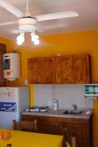 - une cuisine avec des placards en bois et un réfrigérateur blanc dans l'établissement Posada del Flamenco, à Miramar