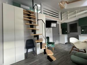 a living room with a spiral staircase and chairs at Beautiful and Unique Apartment on the 3rd Floor-MEZZANINE in Kraków