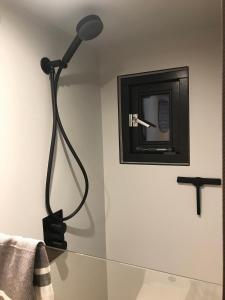 una lampada nera su un muro accanto a uno specchio di Slapen op de Dijk - Tiny House a Kraggenburg