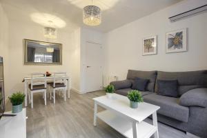 uma sala de estar com um sofá e uma mesa em Apartamento San Isidro - Elegante y centrico apt. p/5 con Wifi y AC em Alcalá de Henares