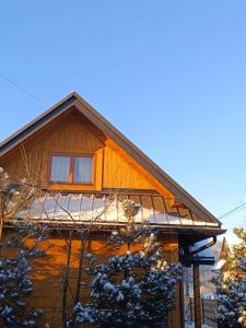 a log cabin with snow on the roof at Domek we wsi, Pieniny, Jezioro Czorsztyńskie in Krośnica