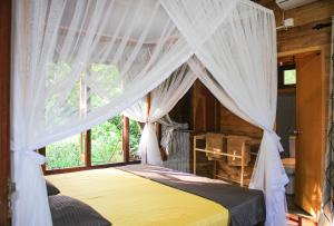 a bedroom with a canopy bed with white curtains at Seasons Four Jungle Treehouse in Matara