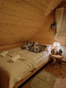 a bedroom with a bed in a log cabin at Domek we wsi, Pieniny, Jezioro Czorsztyńskie in Krośnica